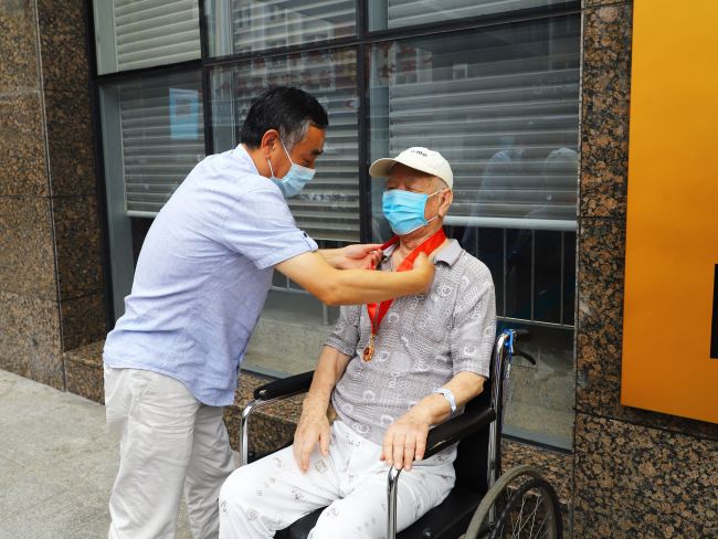 汪啟來(lái)為張建黨佩戴“光榮在黨50年”紀(jì)念章（修圖）.jpg